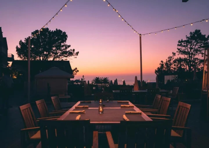 An outdoor dining table underneath a purple dusk sky