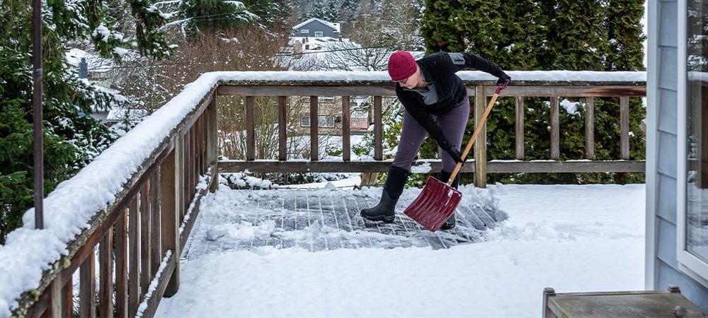 man removing snow from deck
