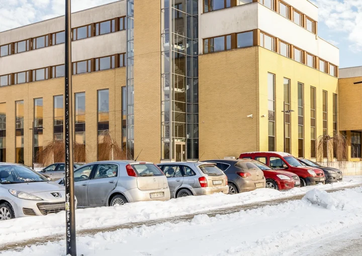 modern office building on bright winter day, snow covered parking area