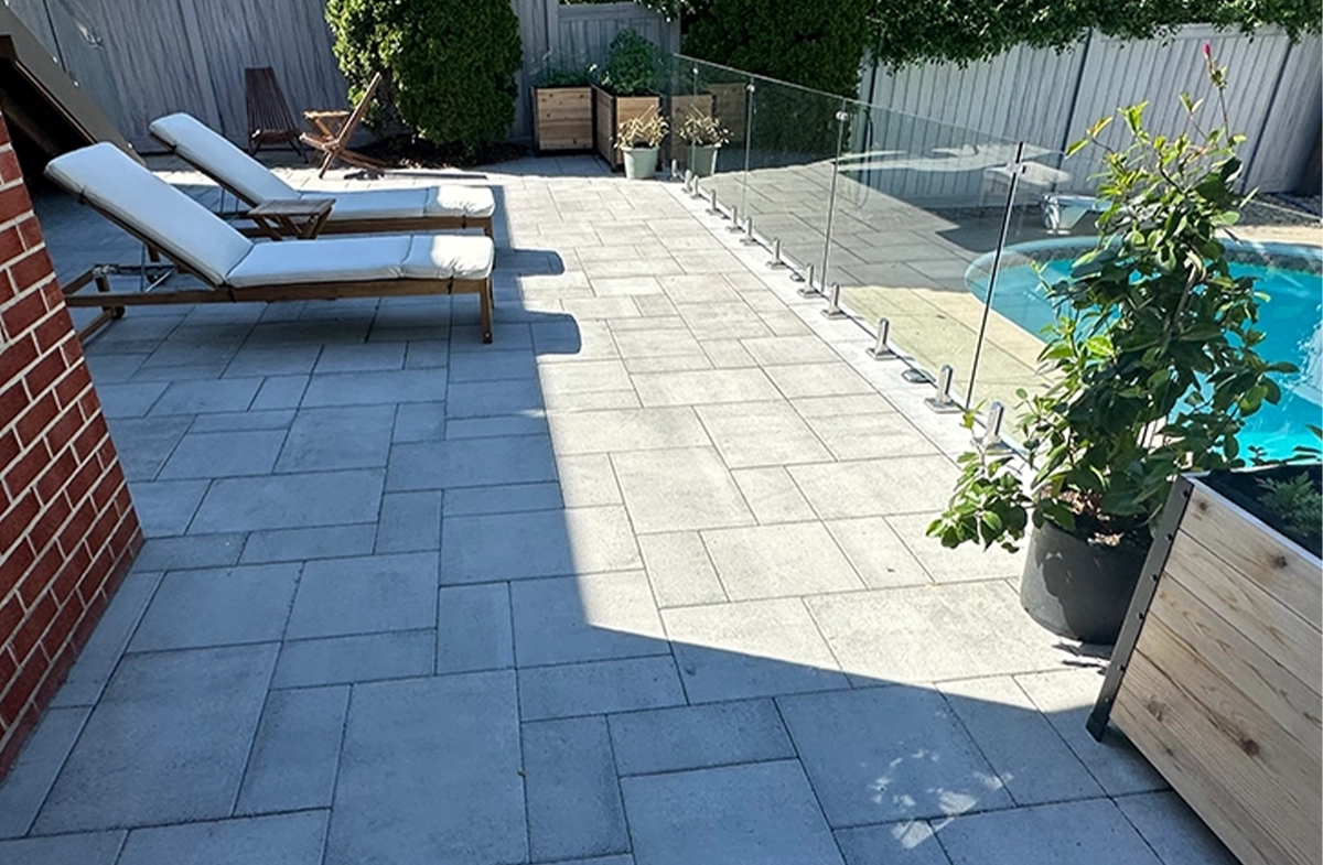 glass railing between interlocking patio and pool