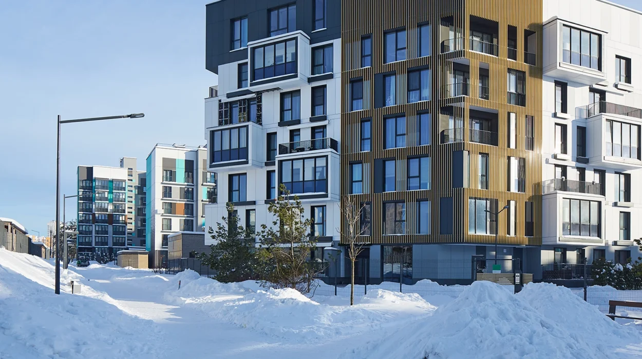 New modern block of flats in green area at winter. residential apartment with flat buildings exterior. luxury house complex covered snow. condo