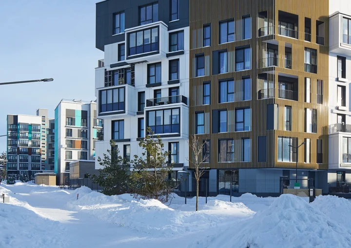 New modern block of flats in green area at winter. residential apartment with flat buildings exterior. luxury house complex covered snow. condo