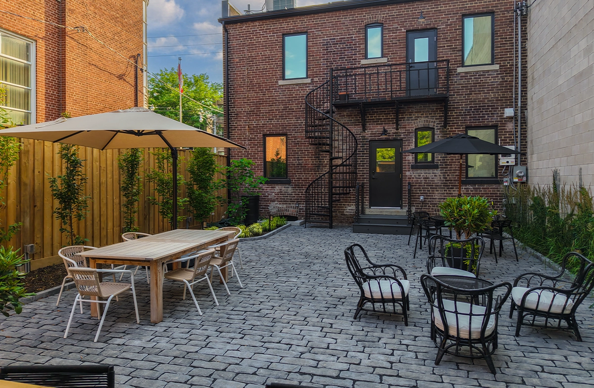 open bar with sitting setup, fence, landscaping, paver floor, brick walls building