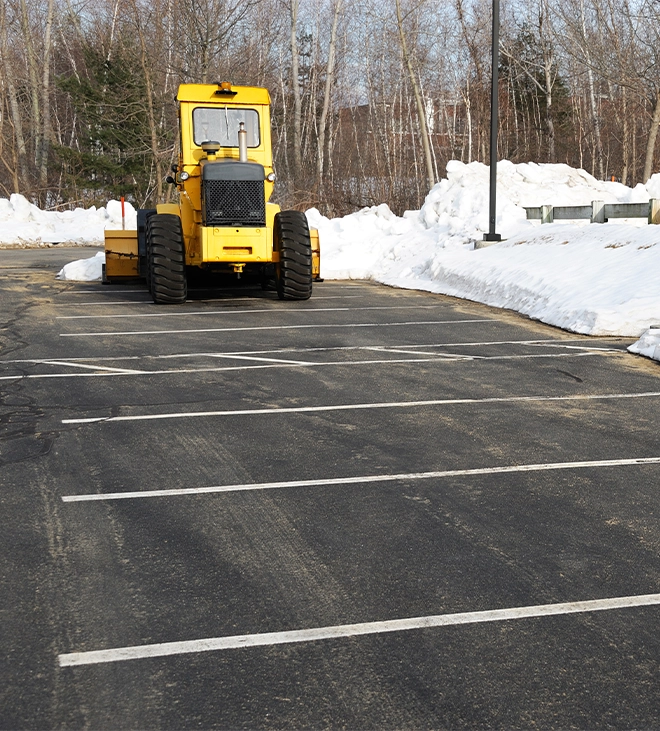 snow plow removing snow on parking area