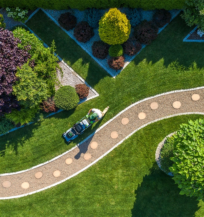 top view of beautiful garden, gardener cutting grass