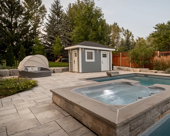 swimming pool with plunge pool and interlock deck in backyard