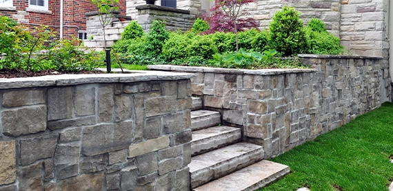 armour stone retaining wall with steps in yard