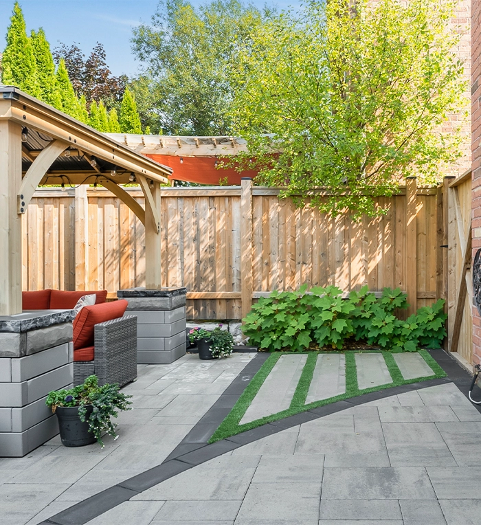 backyard fence and interlock surface with landscaping