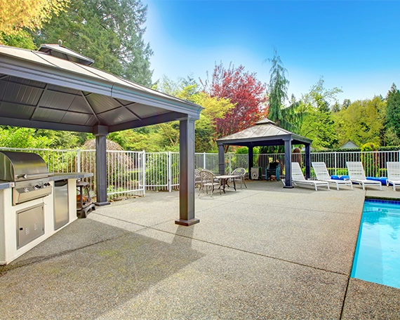 bbq setup covered under patio cover, cabana, concrete pool deck
