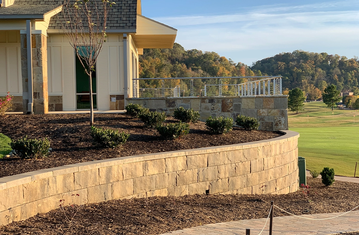 large concrete block retaining wall holds back soil and prevent soil erosion beside luxury home