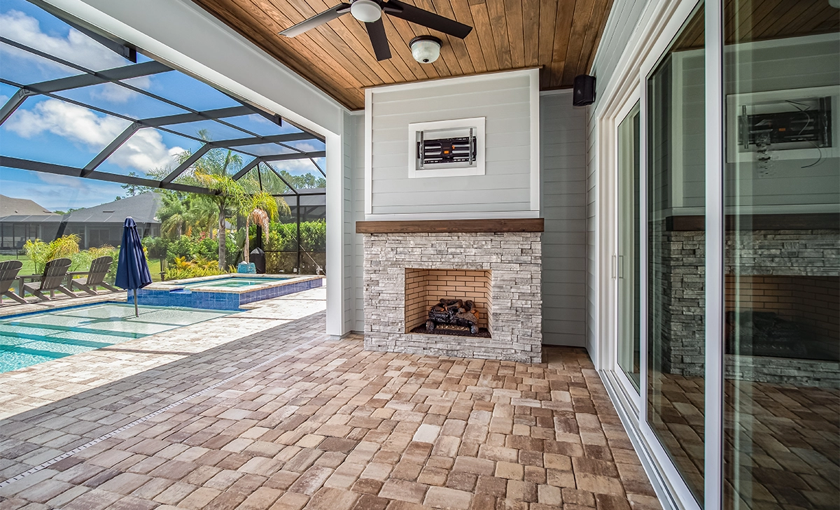 covered interlock patio, pool with pool cover, home backyard, wooden ceiling and sliding door