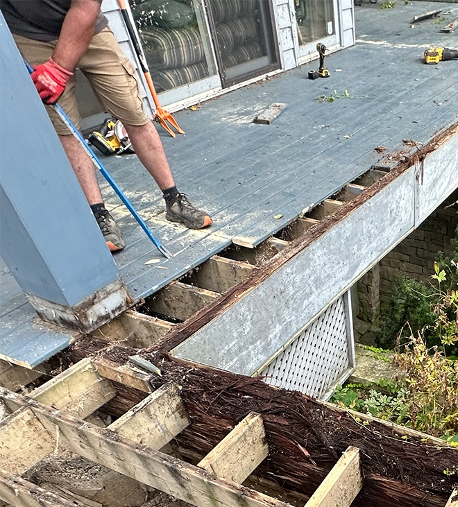professional man inspecting deck using rod