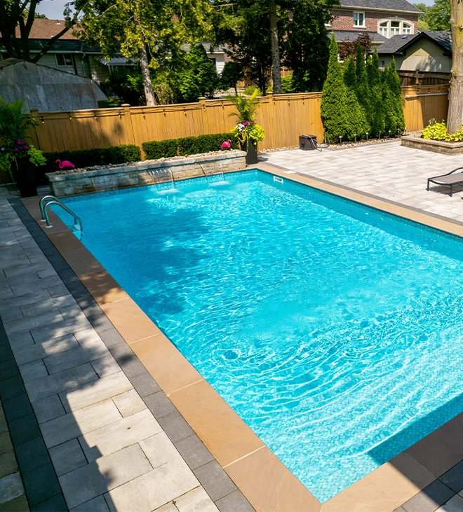 vinyl pool with interlocking floor, landscaping and fence in backyard