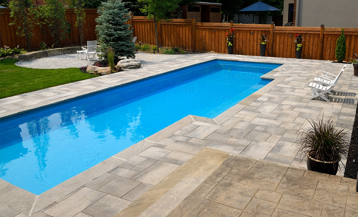 fibreglass pool with interlocking patio large fibreglass pool with interlocking patio, full backyard view, wooden fence and landscaping