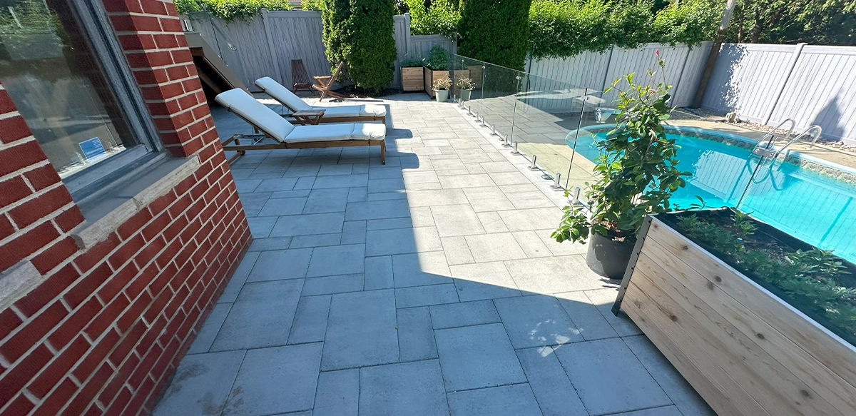 glass railing between pool and interlock patio. backyard surrounding cover with fence