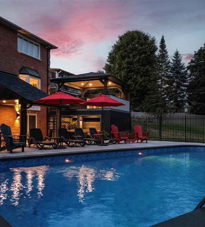 home backyard concrete pool light feature in concrete pool, backyard view, custom carpentry and sitting setup on interlock deck