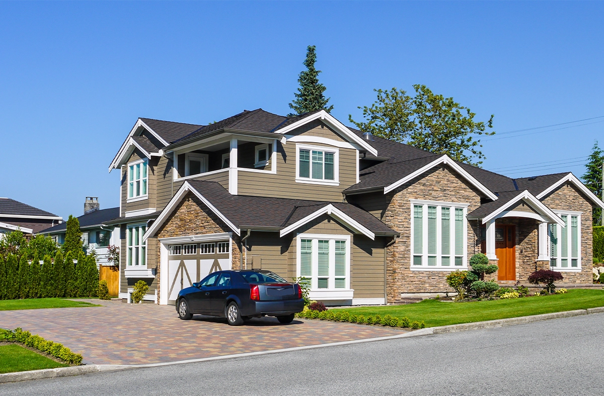 luxury home with side garage and interlock driveway, a car is on driveway