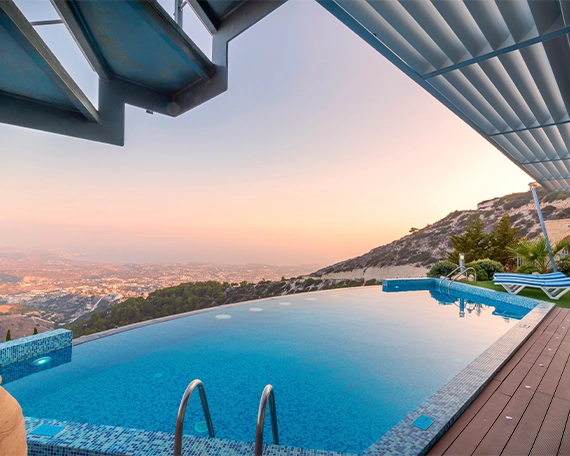 infinity swimming pool with deck and mountain view