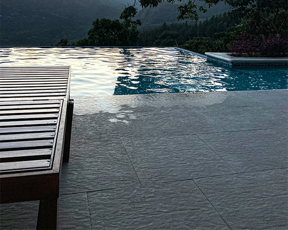 infinity swimming pool, deck on concrete floor and on pool, mountains front view