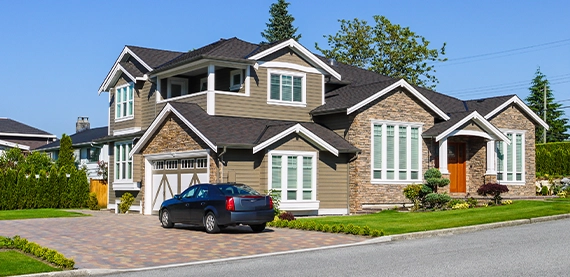 luxury home with side garage and interlock driveway, a car is on driveway