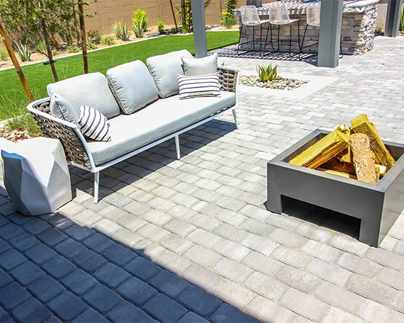 coach in front of fire pit in interlock patio