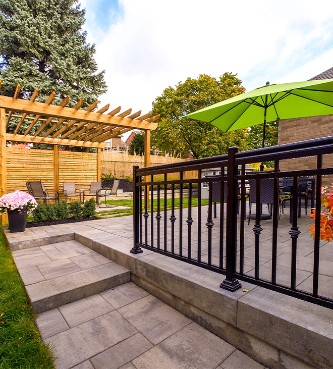 interlock steps toward backyard with side railing, sitting setup under cabana