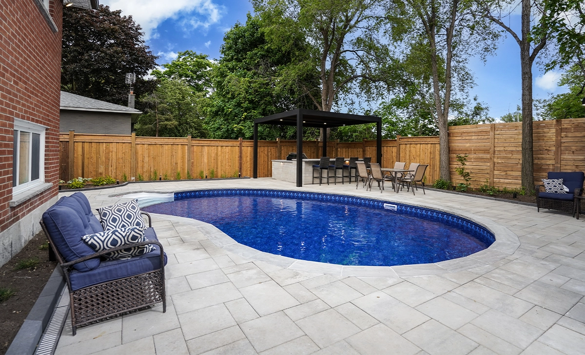 landscaping and interlocking around pool in backyard