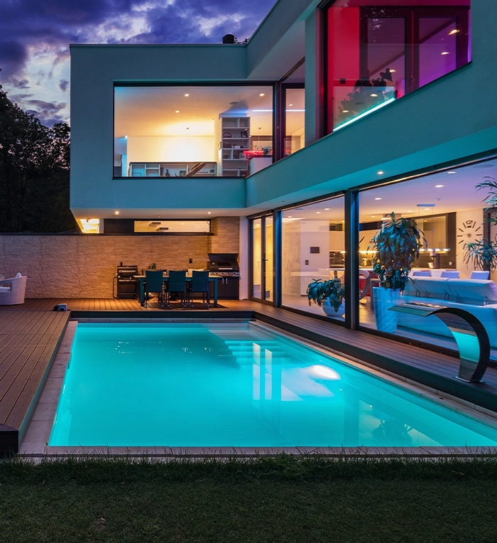 modern home backyard, vinyl pool with lighting feature, deck and sitting setup