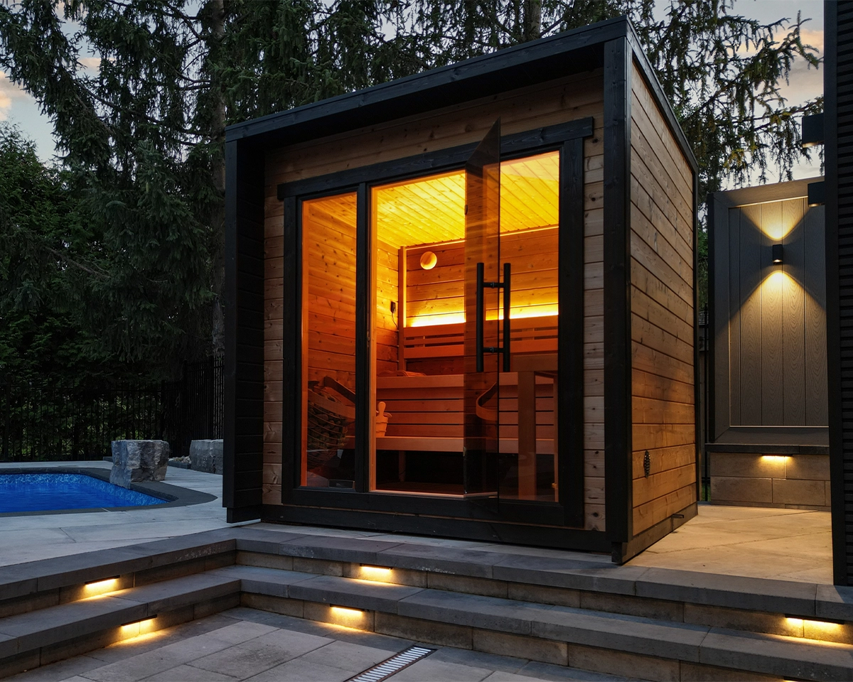 outdoor sauna on interlock surface around pool with lighting features on steps