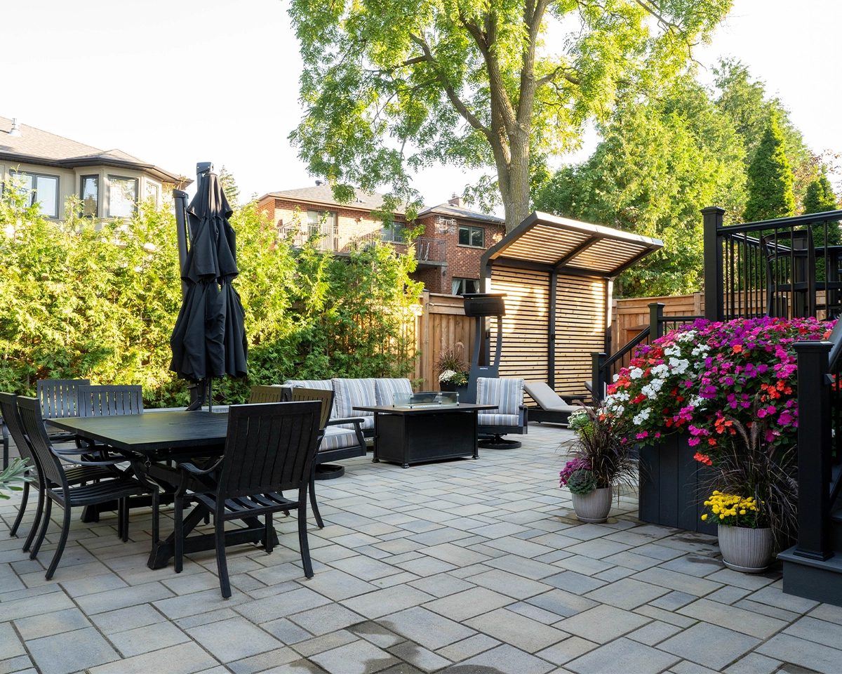 beautiful backyard view, flowers in pot, sitting setup, privacy screen, railing and fence, landscaping and interlocking floor