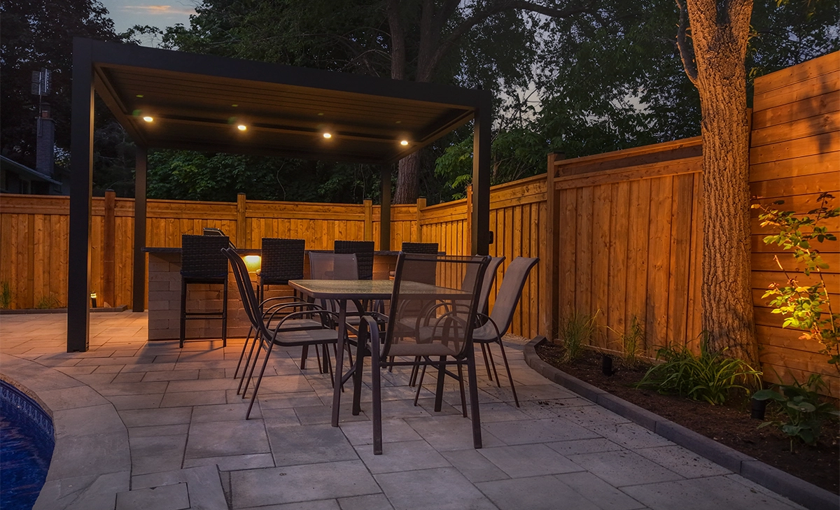 outdoor backyard space surrounded by fence backyard space, covered outdoor kitchen with lighting feature, landscaping and fence