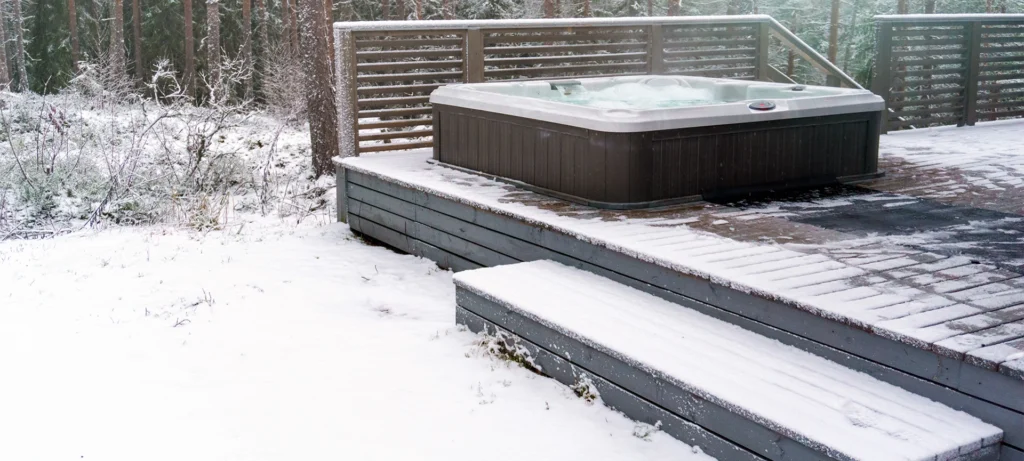 Modern outdoor hot tub on a wooden deck in the cold winter day