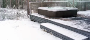 Modern outdoor hot tub on a wooden deck in the cold winter day