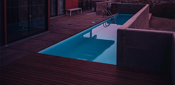 pool deck image six wooden and interlocking deck around pool, evening view