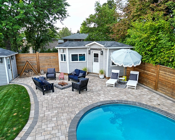 pool deck image three top view of full backyard, interlocking surface around swimming pool, custom carpentry, wooden fence and sitting setup