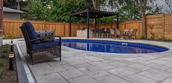interlocking surface around pool with water drainage system.