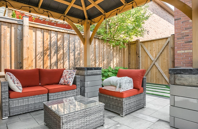 seating area under cabana and wooden fence in backyard