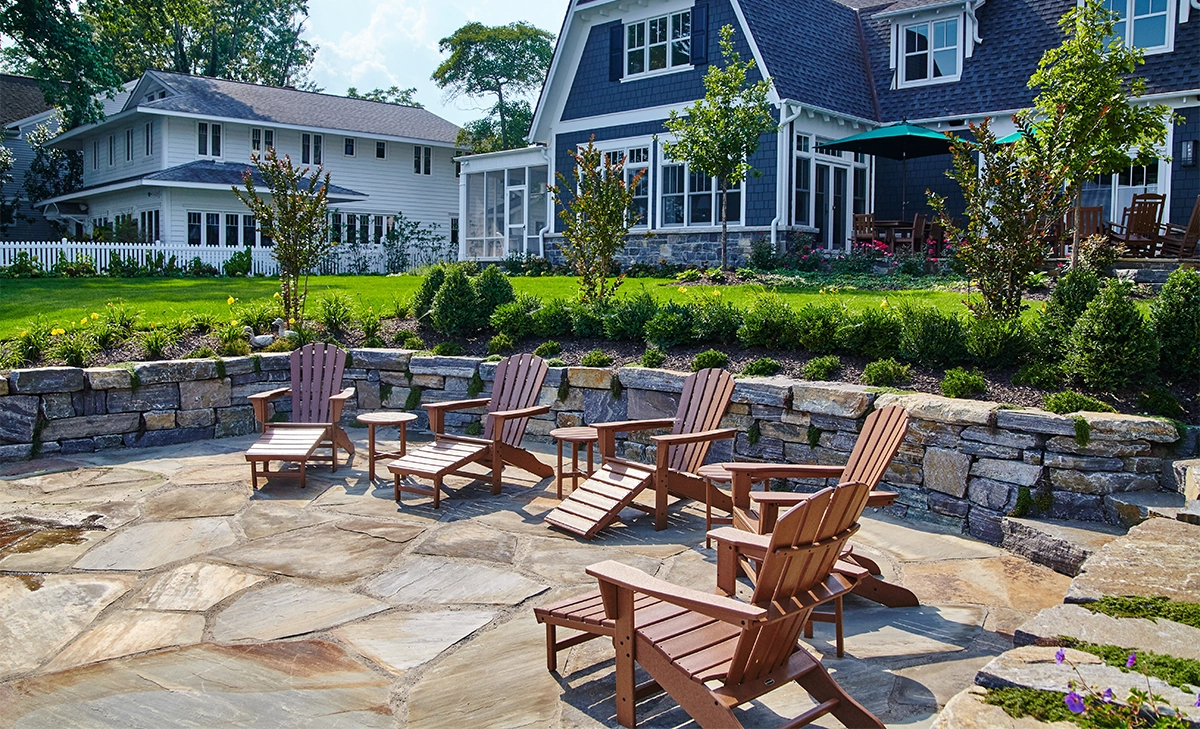 small armour stone retaining wall and yard with chairs in front of residential building