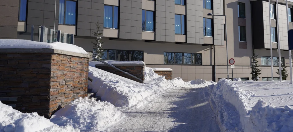 snow covered around driveway in front of commercial building