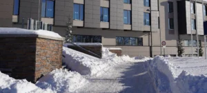 snow covered around driveway in front of commercial building