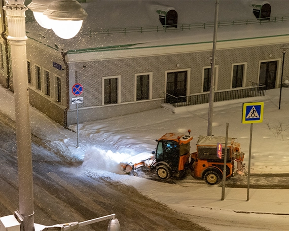 snow removal image nine snow removal tractor clearing snow from road at night