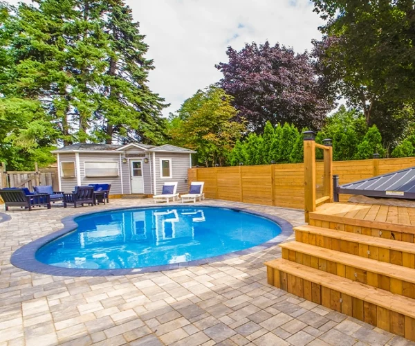 interlocking surface around swimming pool, custom carpentry, wooden deck and seating area in home backyard