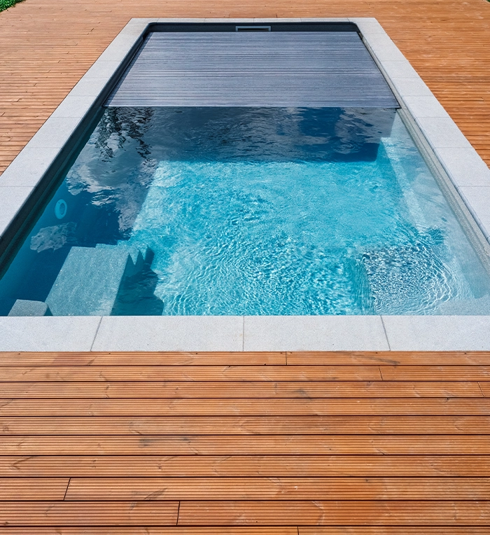 swimming pool with a automatic pool cover on trex deck