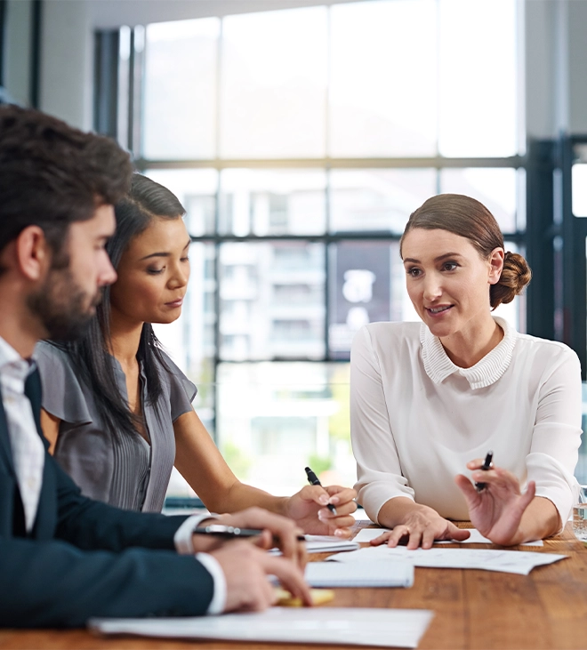 two women and one man in team discussing about project sitting in office