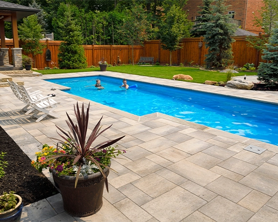 family enjoying in vinyl pool, interlocking deck around pool
