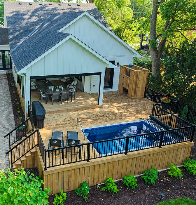 wooden large deck with built in pool, aluminium railing and stairs in home backyard