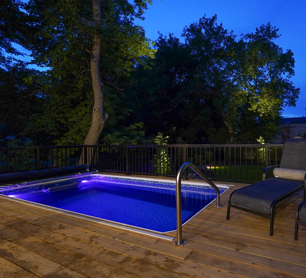 a deck with a pool in it at night