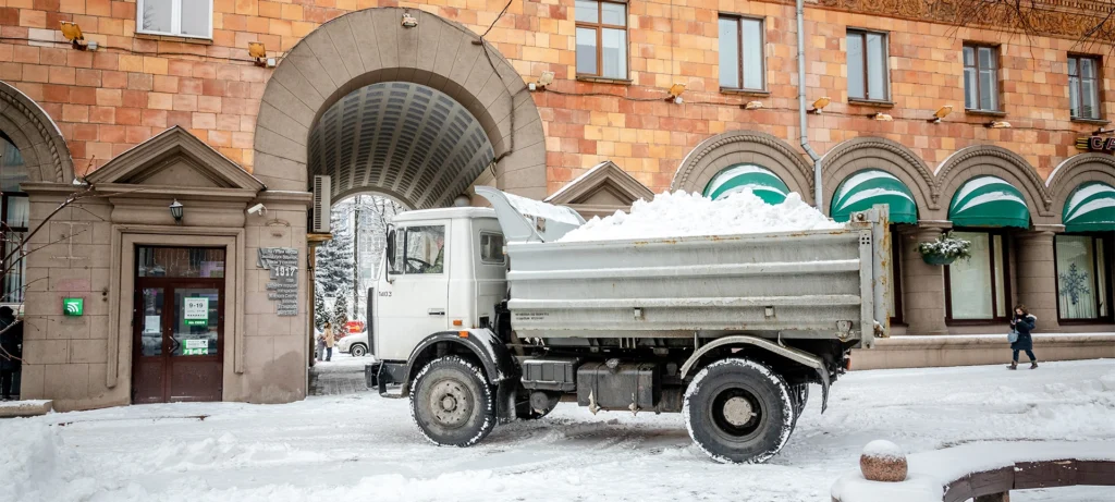 workers and snow machines remove snow in the city center after a snowfall