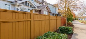 Nice wooden fence around house. Wooden fence with green lawn and trees. Street photo, nobody, selective focus