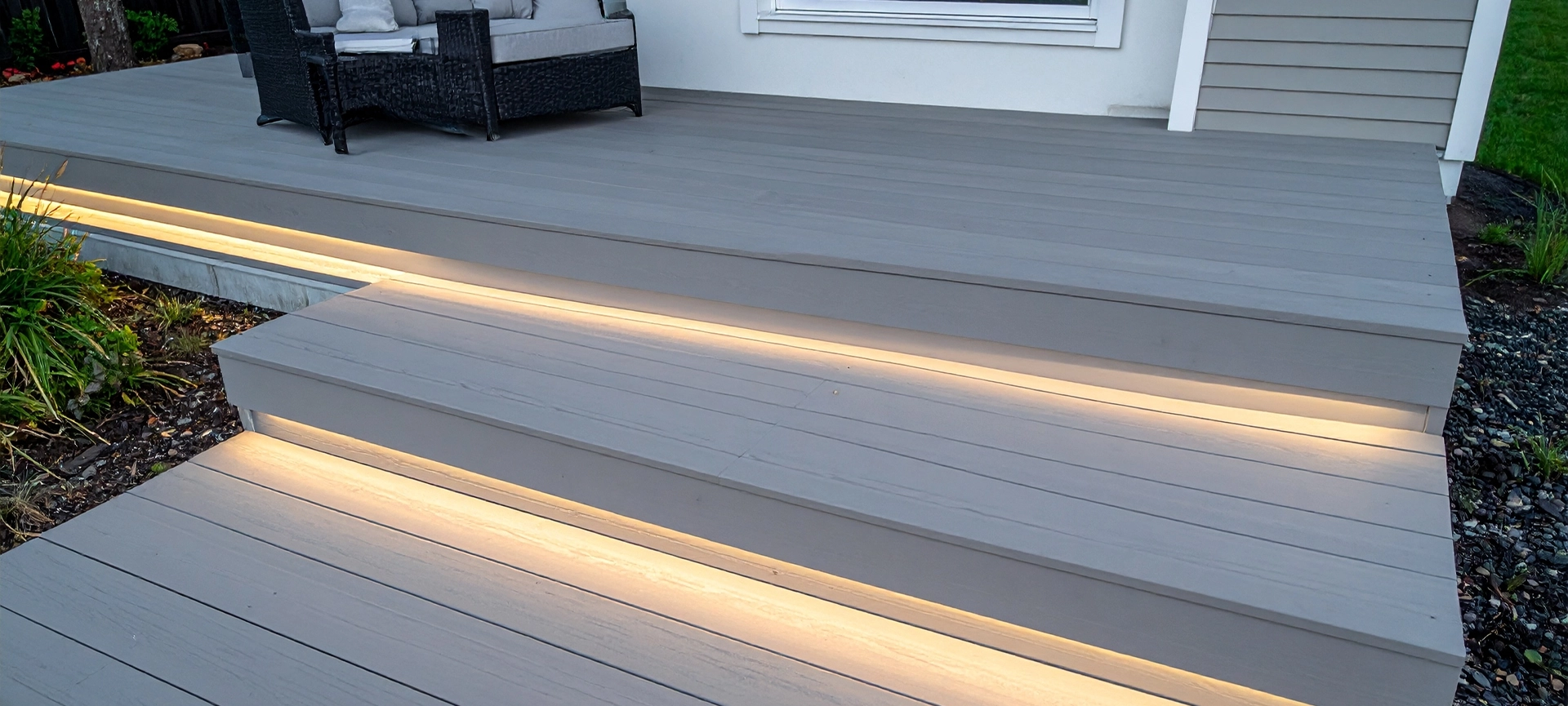 Modern multi-level composite decking in ash grey with subtle deck lights for contempo